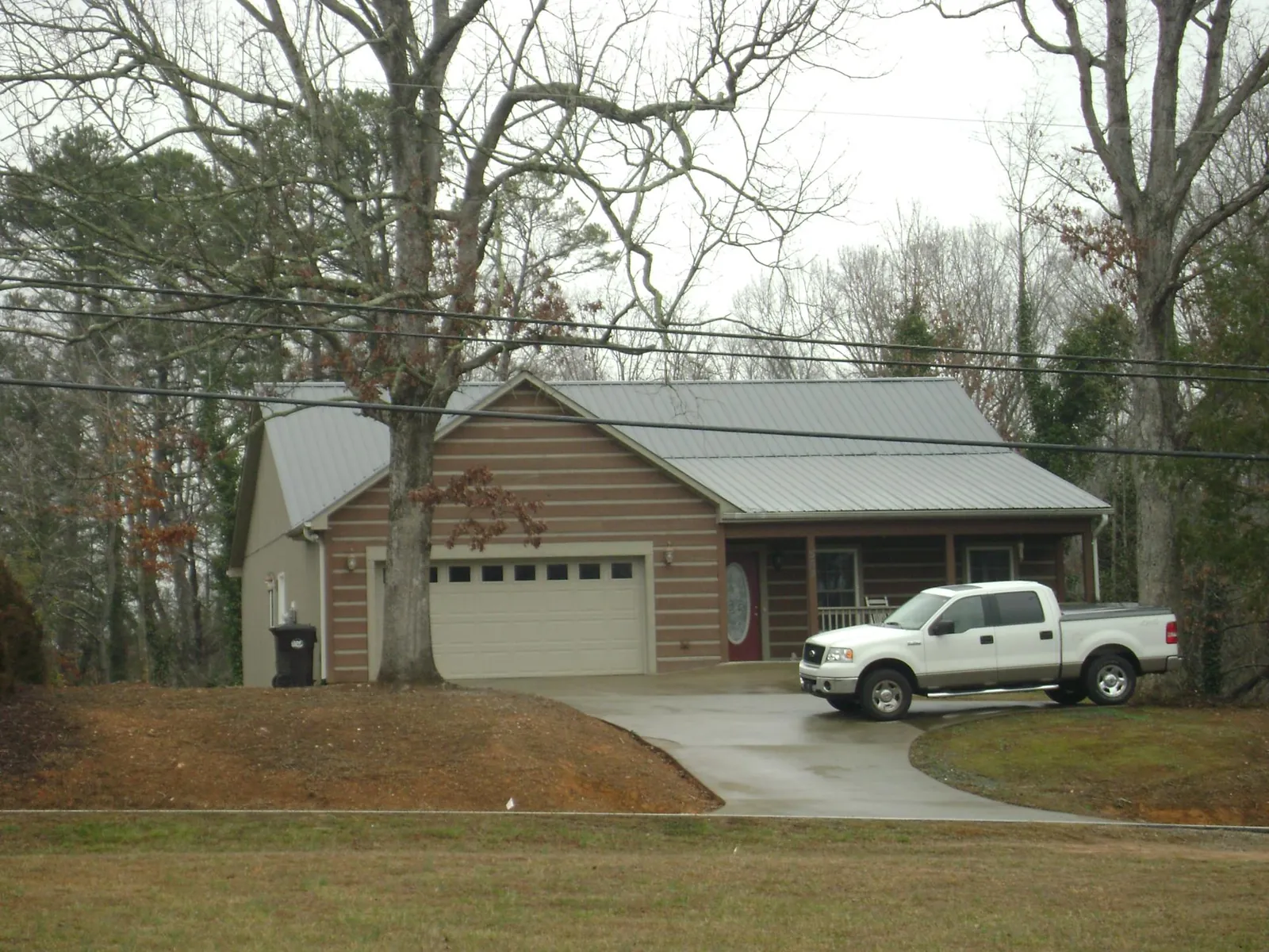Gray metal roof on a log sided house with an attached two car garage in Cloverdale